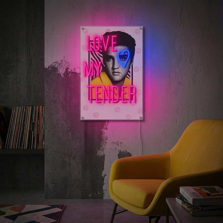 A glowing 'Love Me Tender' neon sign in script font, displayed on a wall above a bed in a cozy bedroom setting, showing its impact as a home decor piece.