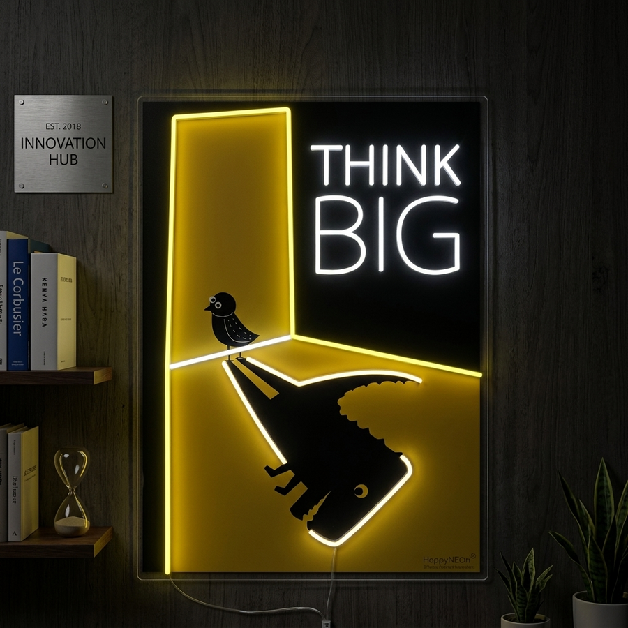 Handcrafted "Think Big" neon sign in a scripted font, illuminating a modern office or studio wall.