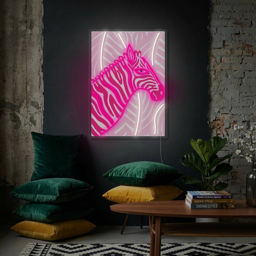 A glowing 'Hot Pink Zebra' neon sign styled as wall decor in a modern, eclectic living room setting, mounted above a velvet sofa.