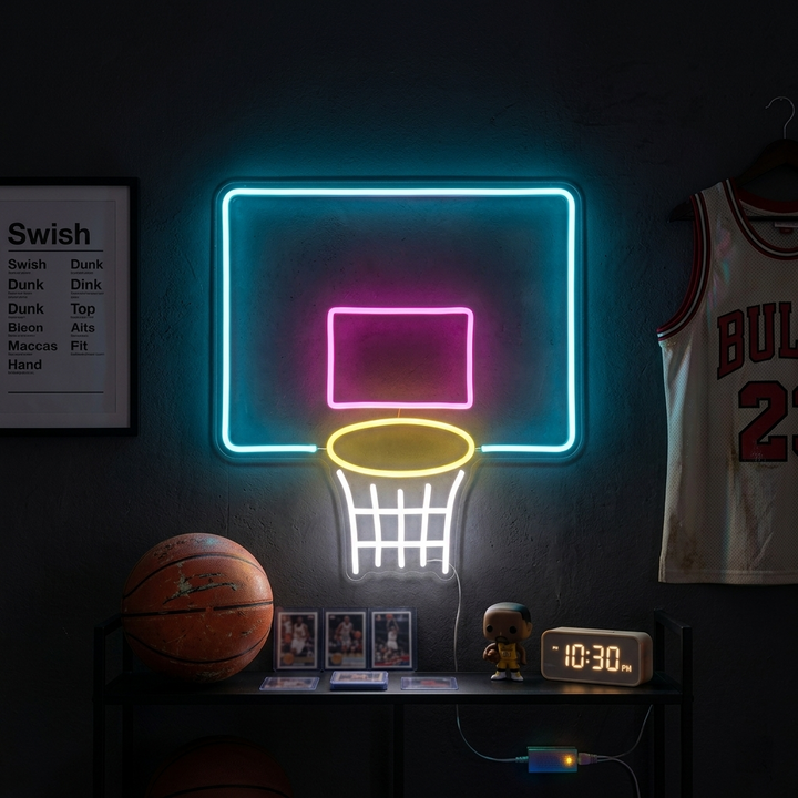 Handcrafted neon sign of a basketball hoop and net mounted on a brick wall, glowing bright orange and white in a room with basketballs.