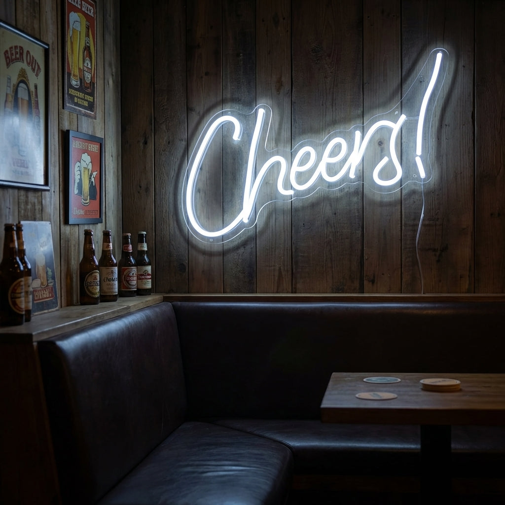 Cheers neon sign in warm white script hanging behind a rustic bar counter