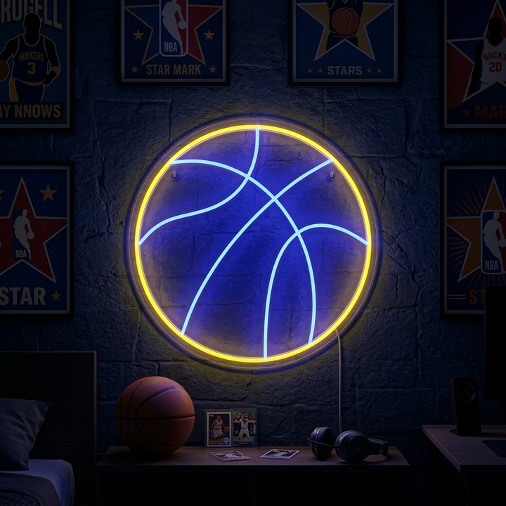A glowing 'Basketball' neon sign, styled like an orange basketball with black lines, mounted on a rustic wood wall surrounded by sports memorabilia.