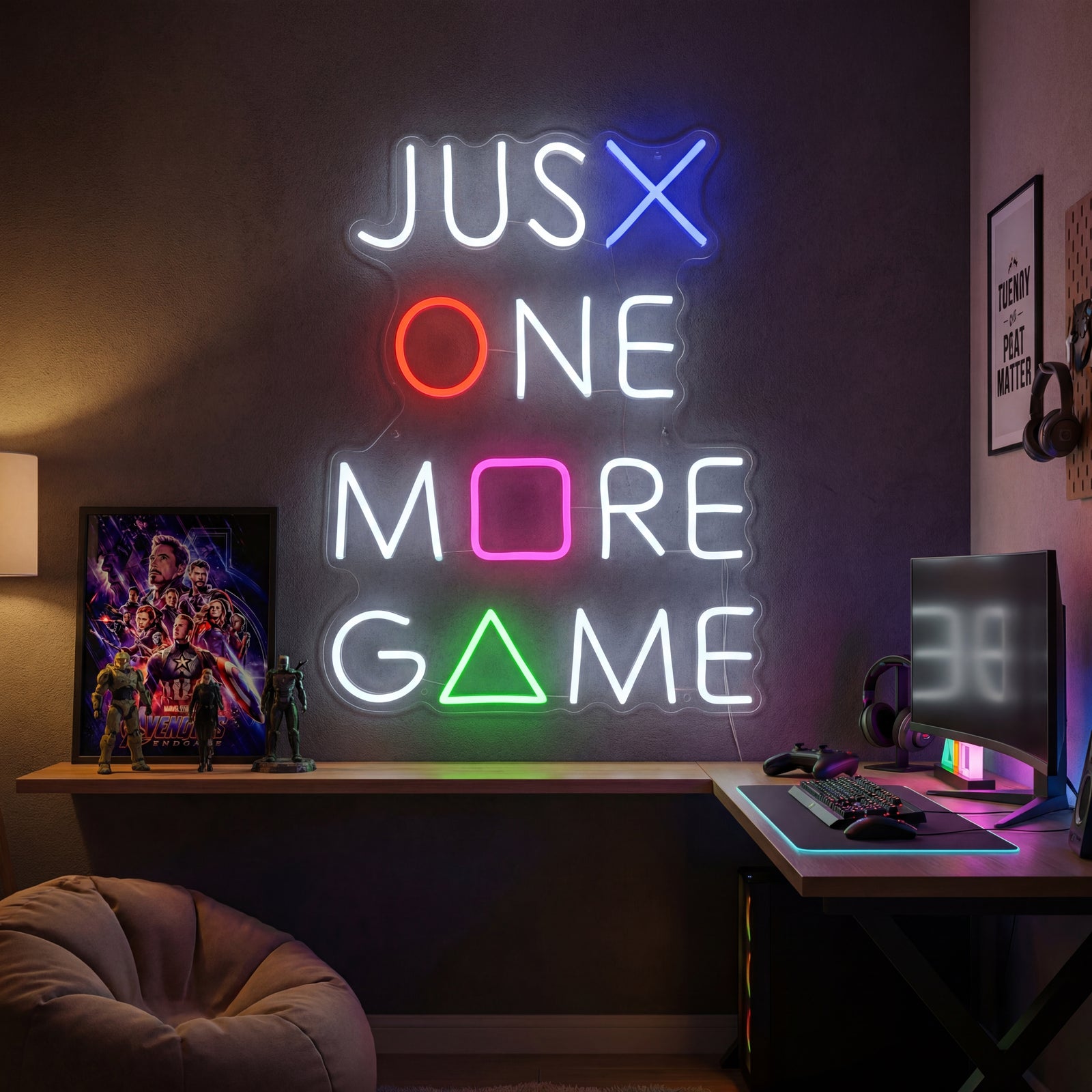 A glowing 'Just One More Game' neon sign displayed on a bedroom wall above a modern desk setup with multiple monitors, gaming peripherals, and figurines.