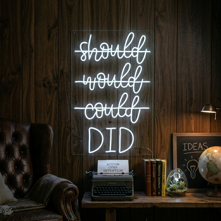 A vibrant 'Should Would Could Did' neon sign mounted on a textured wall, glowing brightly.