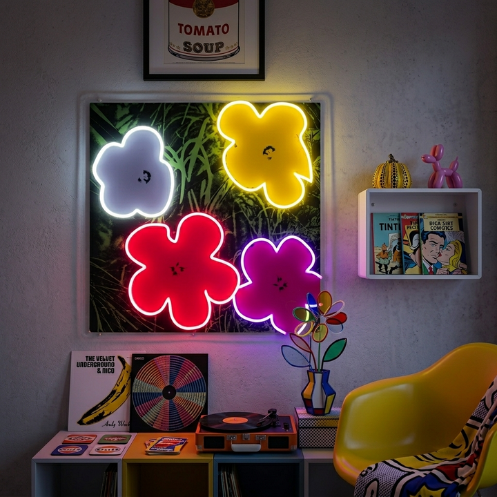 Pop Art In Bloom neon sign with colorful flowers and glowing tubes mounted on a wall in a brightly decorated living room.