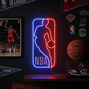 A bright red blue and white basketball logo neon sign glowing against a brick wall