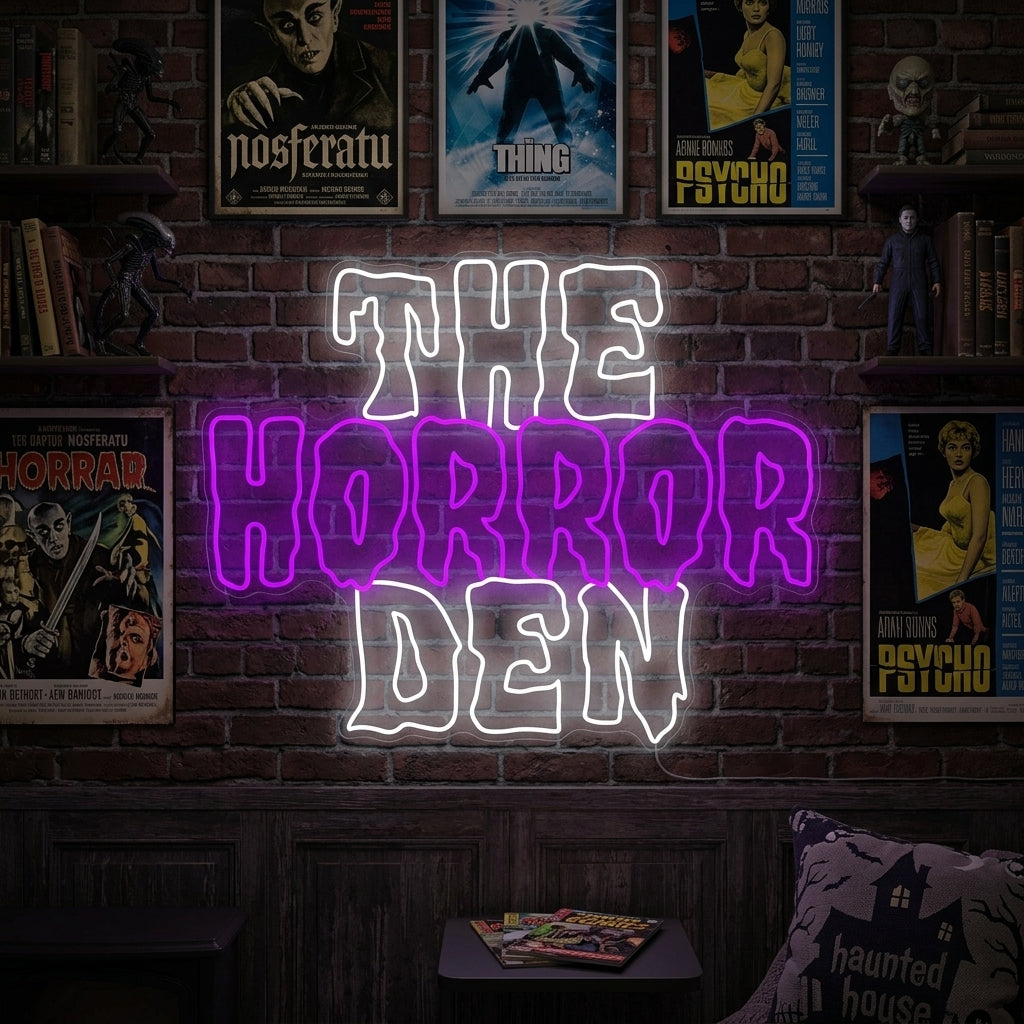 "The Horror Den" neon sign glowing on a wall in a moody, dark room with a plush armchair and spooky decorations.