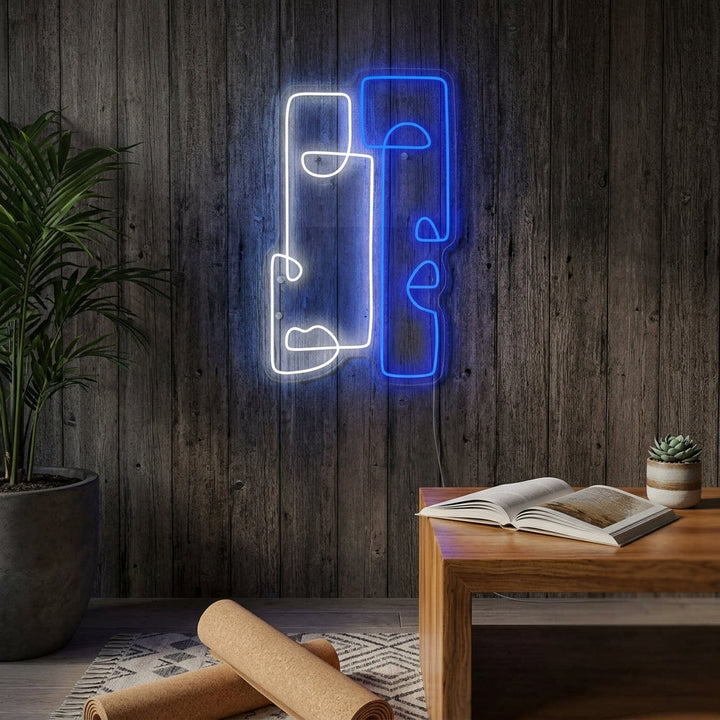 Modern glowing blue 'Abstract Totem' neon sign mounted on a brick wall in a cozy living room, illustrating its use as stylish home decor.