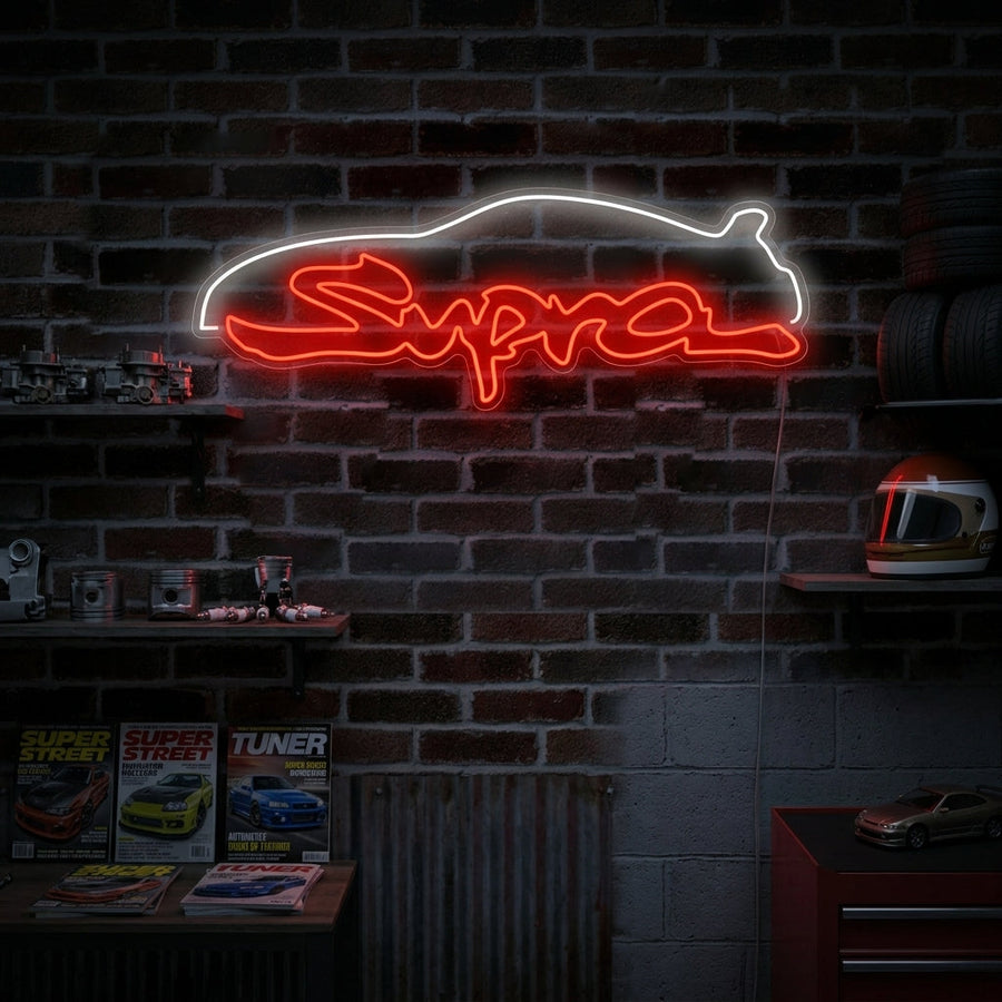 Supra script neon sign glowing in a garage workshop setting above a motorcycle