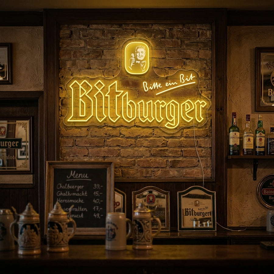 A glowing yellow and green Bitburger neon sign hangs on a wooden wall above a home bar setup.
