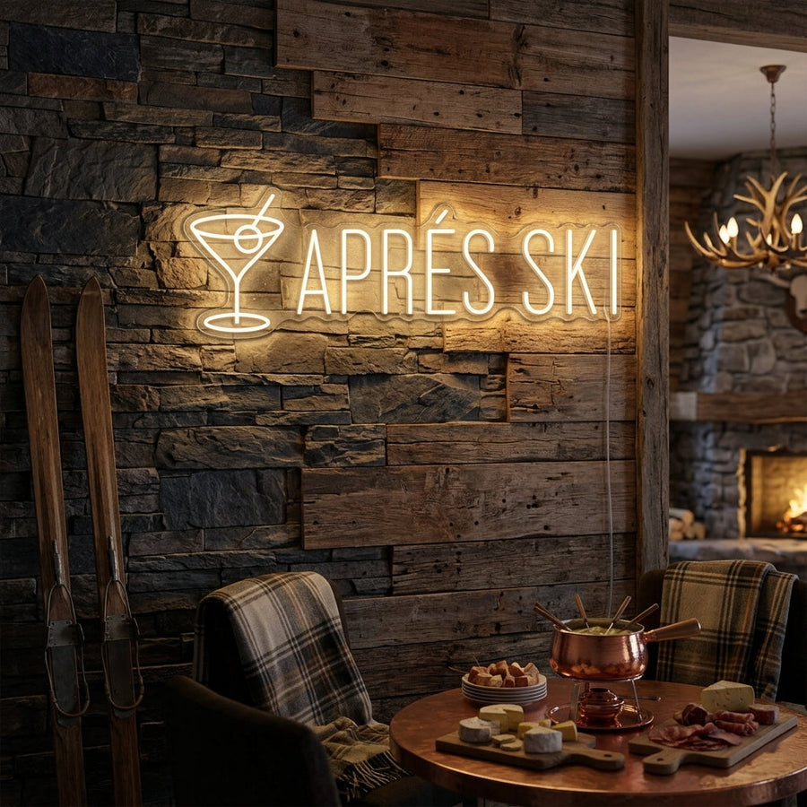 A cozy living room featuring an Apres Ski neon sign glowing blue above a rustic fireplace, with a comfy armchair and blanket nearby.