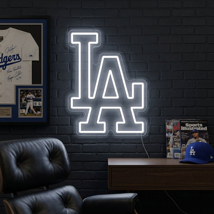 A vibrant 'LA' neon sign glowing on a textured wall in a modern living space.