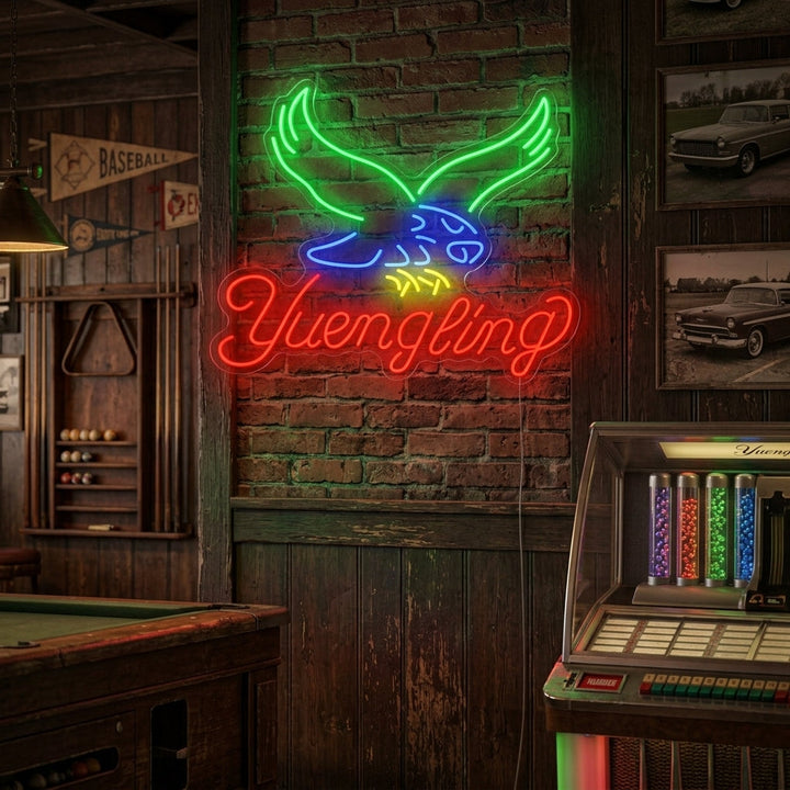 A glowing Yuengling neon sign mounted on a dark brick wall above a well-stocked home bar.