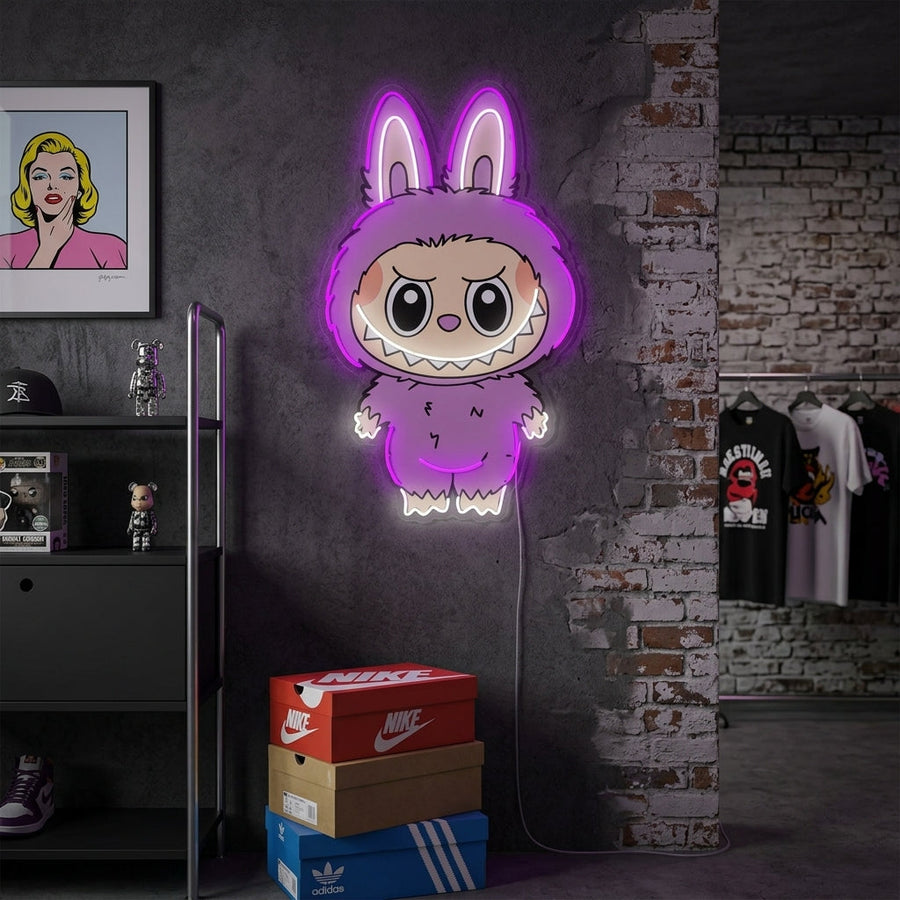 Stylized 'Monster' neon sign glowing in a dark room setting.
