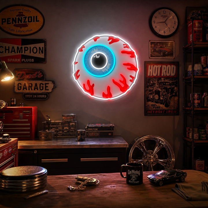 A cartoon zombie eyeball bomb UV print neon sign displayed on a dark grey wall in a dim room. The sign features a bloodshot eyeball with a lit fuse, emitting a glow that highlights its graphic details and purple/yellow color scheme.