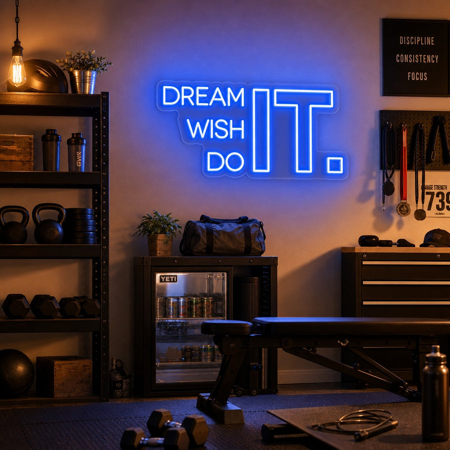 Motivational 'Dream It Wish It Do It' neon sign glowing in white and pink scripts on a textured gym wall.
