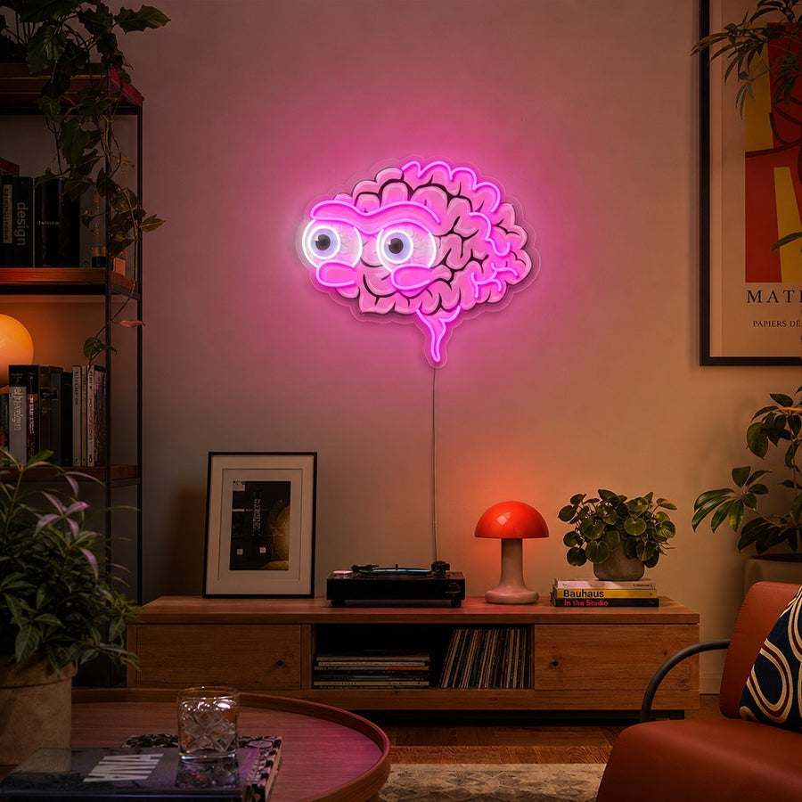 The 'Eyeball Brains' UV print neon sign glows with vibrant blue and white light, mounted on a dark, textured wall, showcasing intricate anatomical details and multiple eyes.