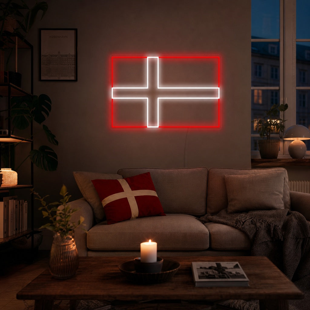 A glowing neon sign depicting the red and white flag of Denmark, mounted on a living room wall above a modern sofa and plants, creating a cozy evening atmosphere.