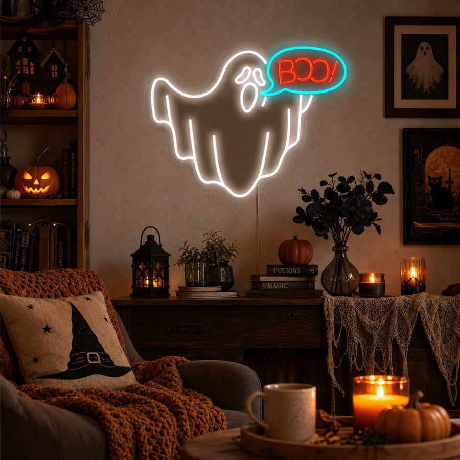 A glowing neon sign of a cartoon ghost saying 'Boo' mounted on a rustic wooden wall above a cozy Halloween-themed display.