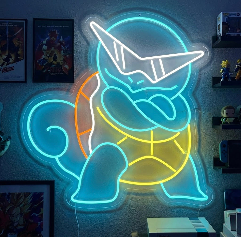 A vibrant cartoon turtle neon sign glowing with bright blue and green light on a wall in a gaming room.