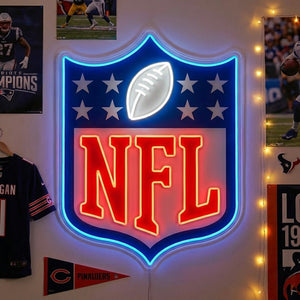 A glowing blue and white American Football Emblem Neon Sign featuring a football silhouette within a shield, mounted on a wall in a cluttered sports fan room with an NFL jersey and pennant in the background.