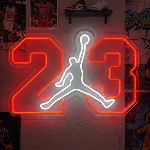 A basketball jump dunk silhouette neon sign mounted on a textured blue wall in a room with warm lighting.