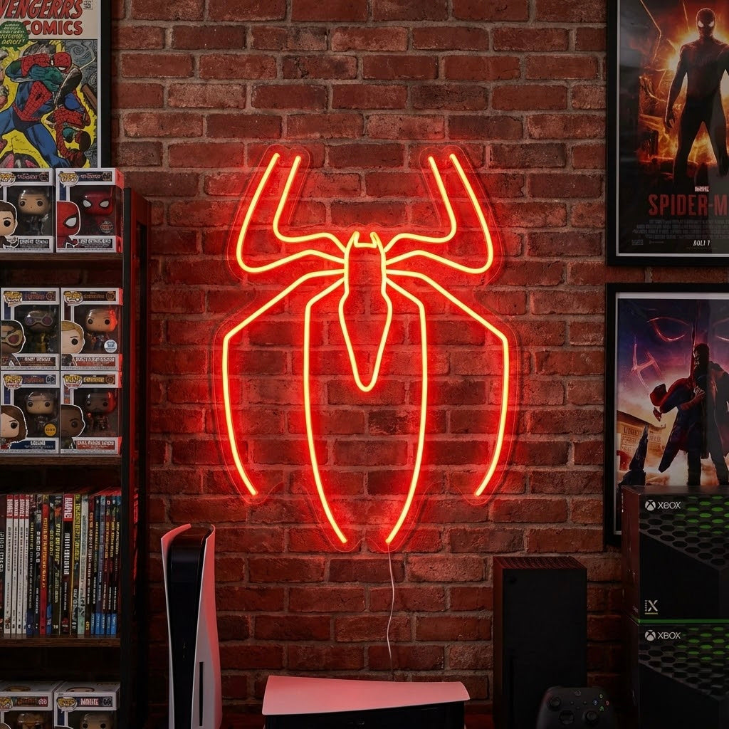 Illuminated red LED neon sign depicting the silhouette of a superhero (Spider-Man) perched on a ledge, mounted above a desk with game consoles and posters in a dimly lit fan cave.