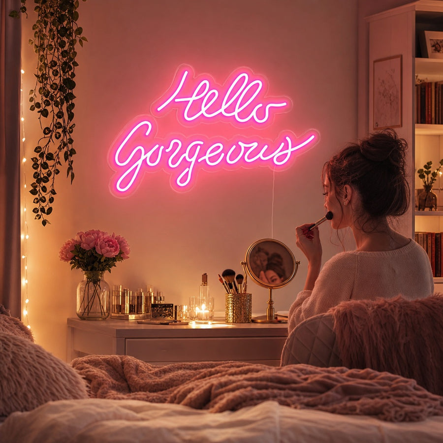 Stylish 'Hello Gorgeous' neon sign in cursive, glowing pink on a textured bedroom wall with decor.