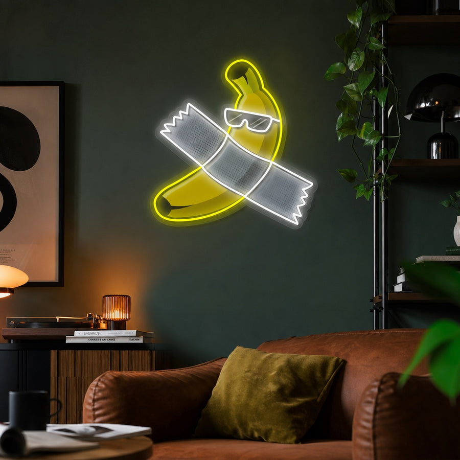 'Is This Art, Banana With Tape' neon sign glowing in a modern art-themed room