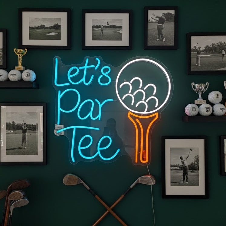 A physical neon sign glowing 'Lets Par Tee Golf' with a golf club graphic, mounted on an acrylic backing against a dark blue textured wall in a decorated golf-themed room.