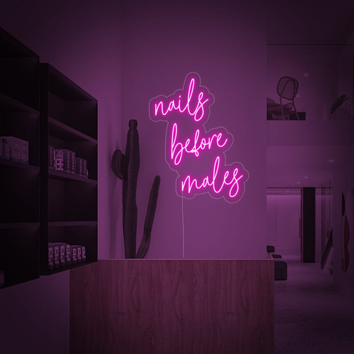 The 'Nails Before Males' neon sign glowing brightly in an urban interior setting, adding a vibrant, pink accent to the decor.
