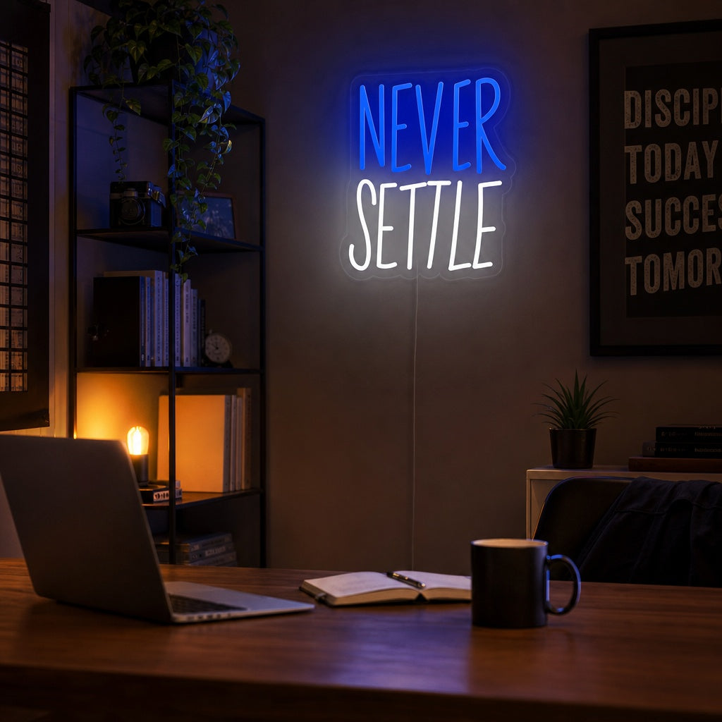 A candid lifestyle photo of the 'Never Settle' neon sign glowing with bright white light in a modern, stylishly decorated living room, mounted above a textured sofa and surrounded by indoor plants and contemporary decor.