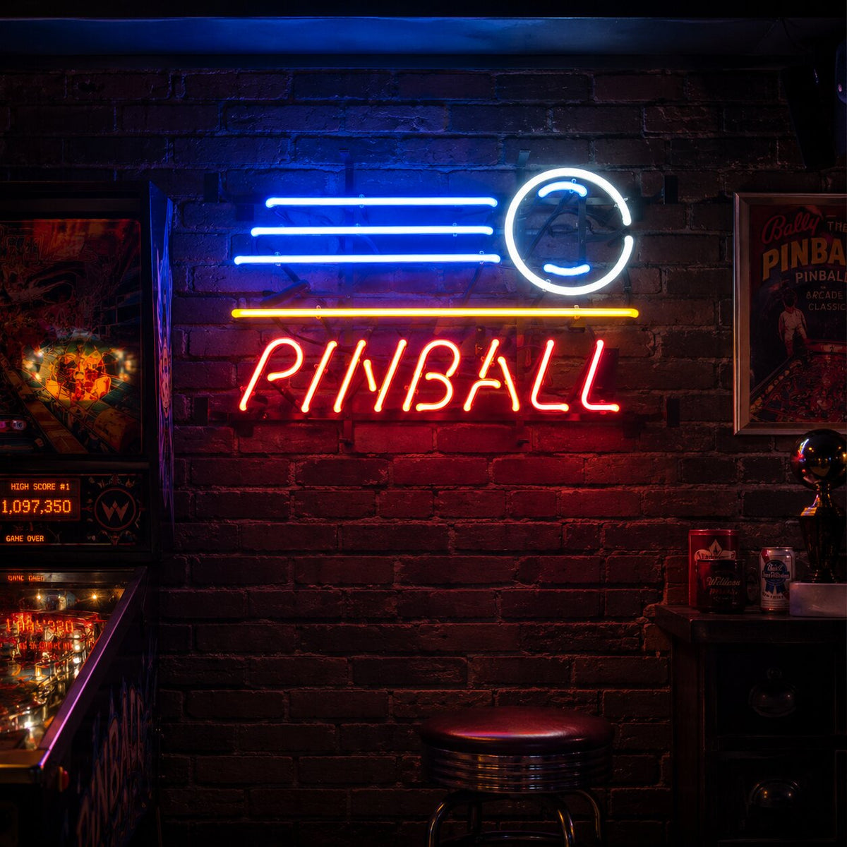 A illuminated blue and orange neon sign reading "PINBALL OPEN" with a pinball and flipper graphic, glowing against a black background.