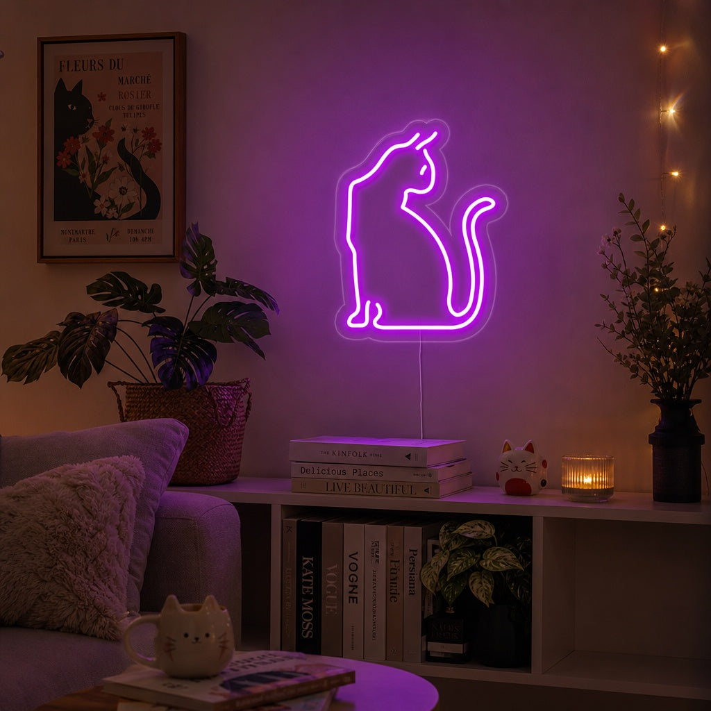 A cute, lit-up pink 'Pussy Cat' neon sign glowing on a textured wall in a styled room.