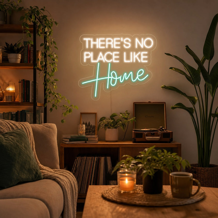 A cozy living room wall featuring a glowing "There's No Place Like Home" neon sign in white script lighting.