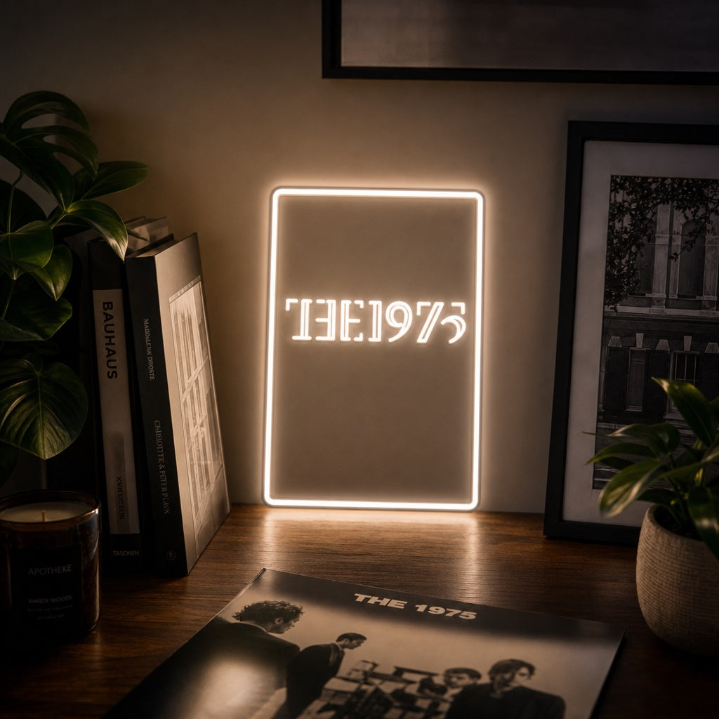 A glowing 'The 1975' neon sign in white text, centered on a light wooden background.