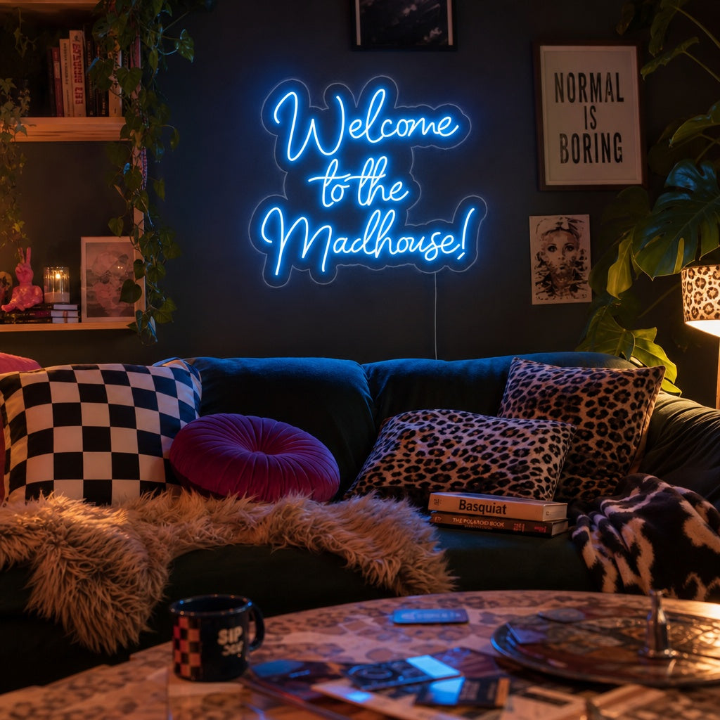 Welcome to the Madhouse neon sign glowing on a textured brick wall in a lifestyle setting.