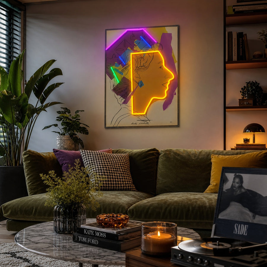 A lifestyle mockup showing the vibrant Abstract Pop Art Queen Collage neon sign illuminated on a textured wall in a modern living space.