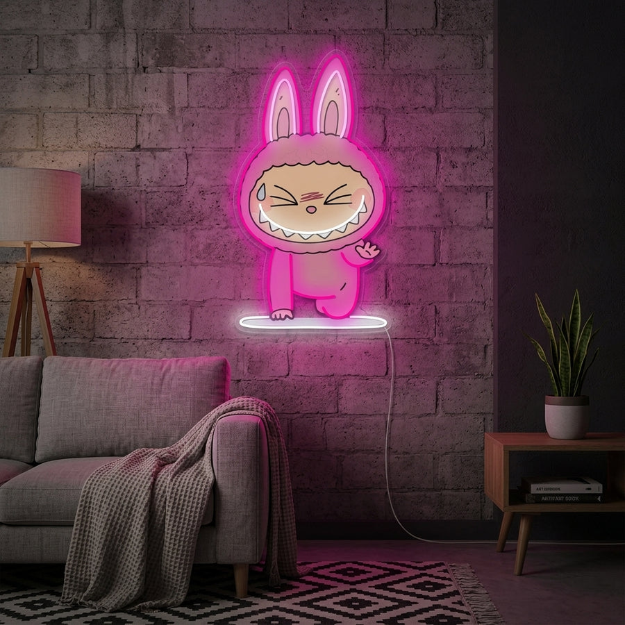 A cozy living room wall with a couch and plants, featuring the glowing 'Yoga Monster' neon sign.