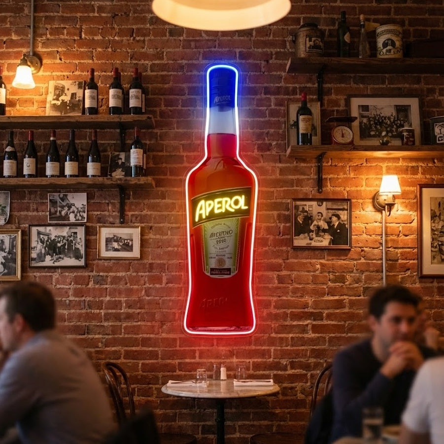 A custom-designed neon sign mimicking an Aperol Spritz bottle, emitting a vibrant orange light, positioned in a well-lit bar setting.
