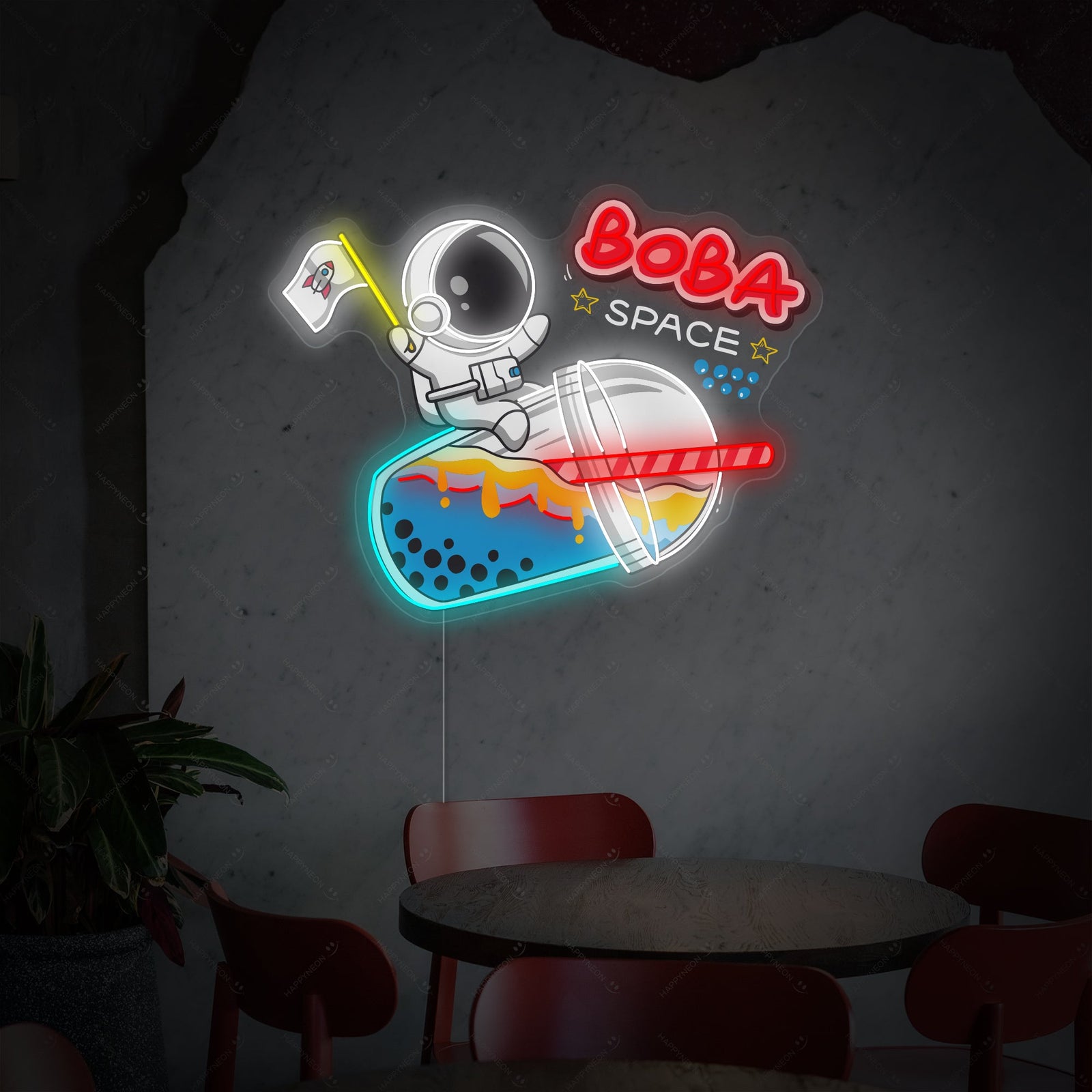 A glowing neon wall sign featuring an astronaut in a spacesuit drinking boba tea, against a clear acrylic backing.