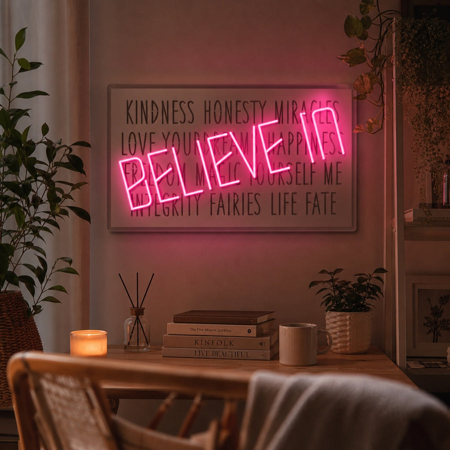 A glowing 'Believe In' neon sign featuring stylish script text in a bright, ambient room, mounted on a wall above modern furniture.