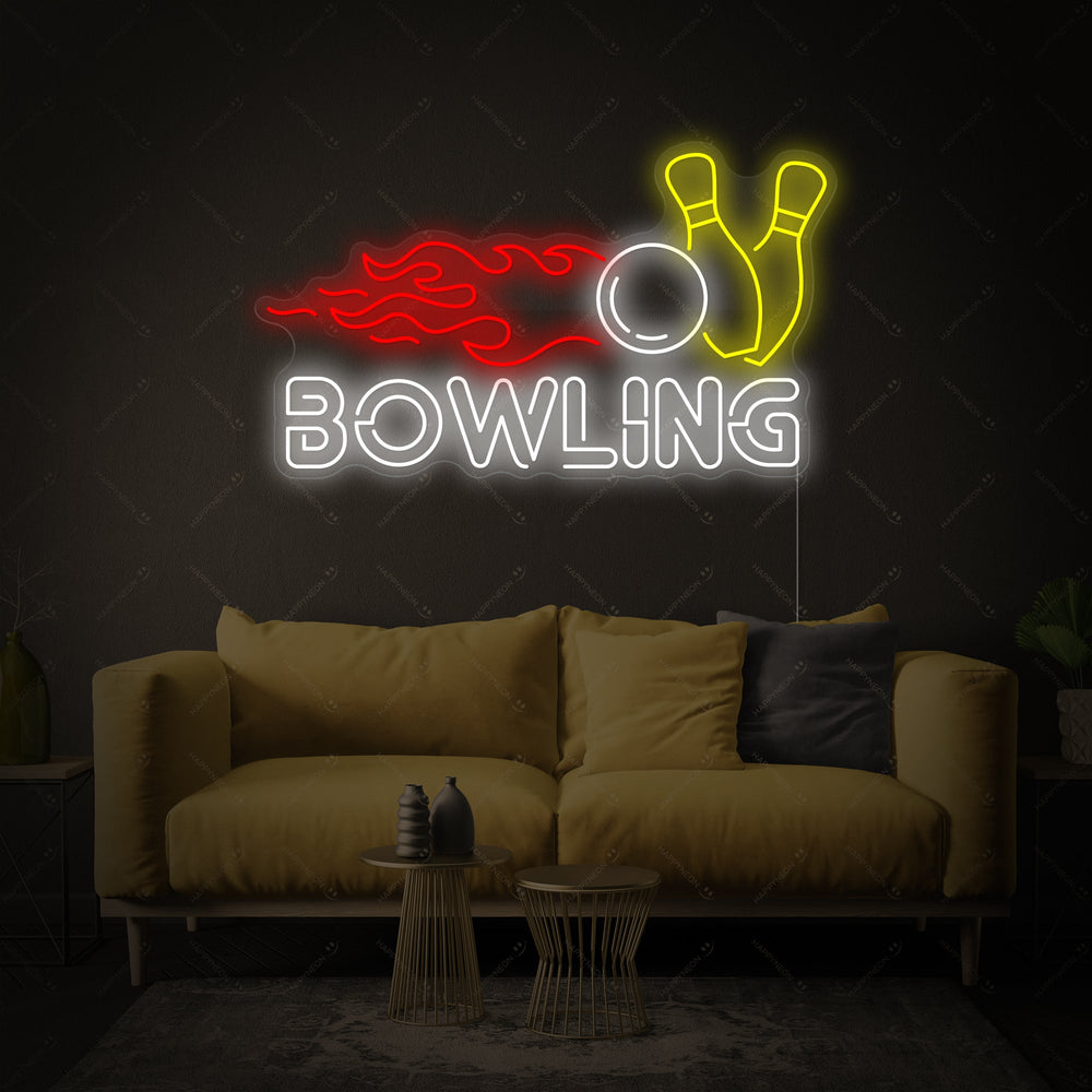 The glowing blue bowling ball and pins neon sign, showing the clear acrylic backing and black power cord against a light grey brick wall.