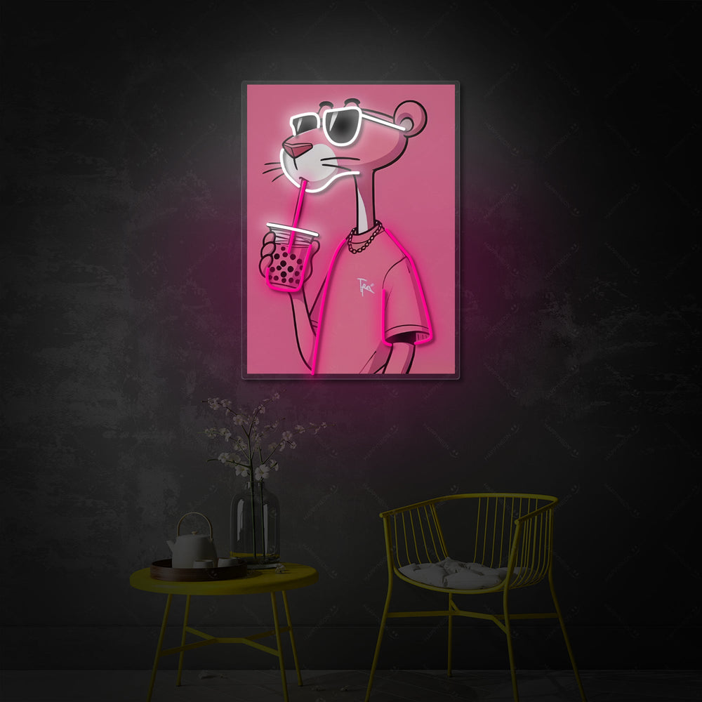A glowing neon sign on a wall depicting the Pink Panther character wearing sunglasses and holding a bubble tea with a large straw, shown in a cozy room at night.