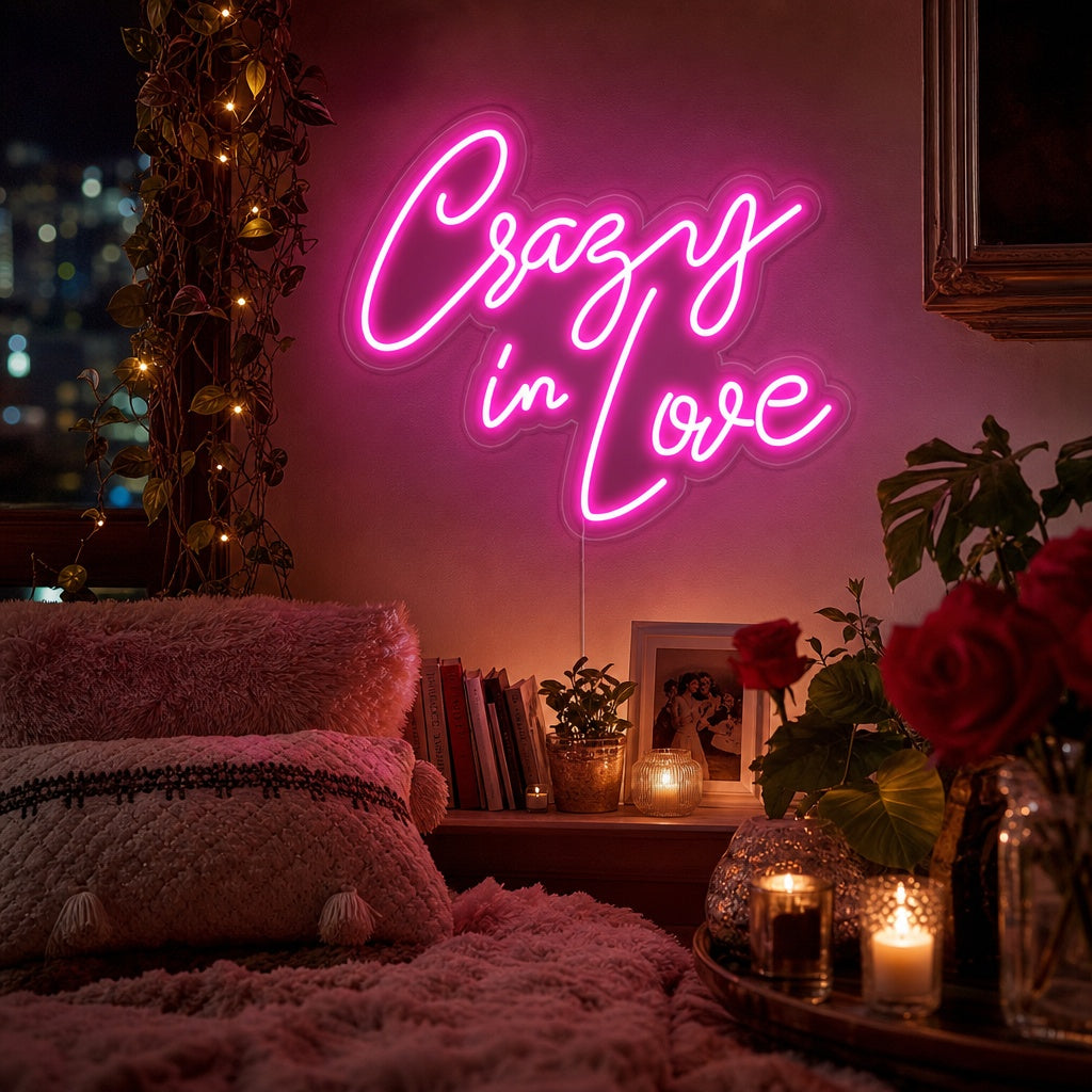 A vibrant magenta pink 'Crazy in love' neon sign glowing above a bed in a stylishly decorated bedroom with textured wallpaper and modern furnishings.