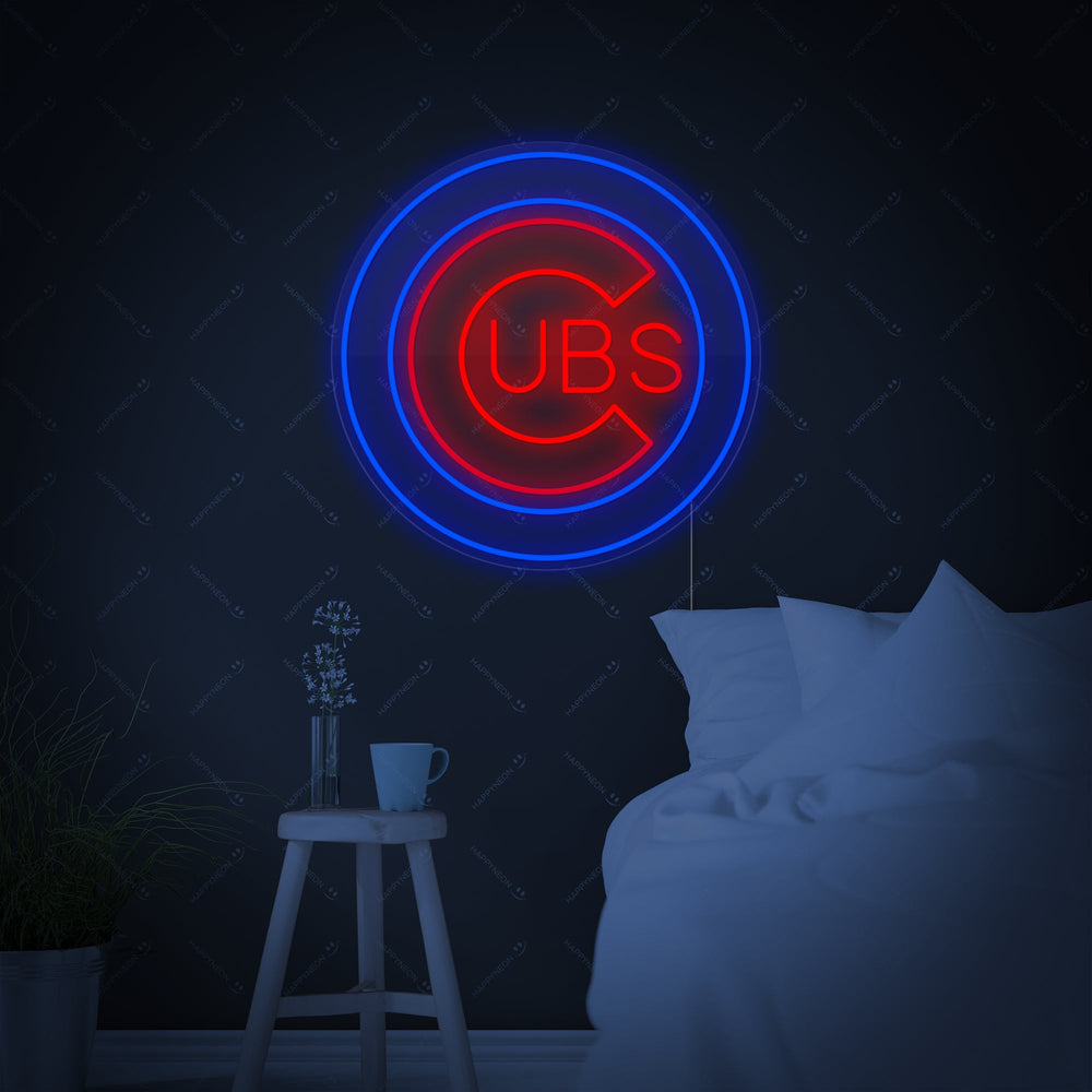 A vibrant 'CUBS' neon sign with text in a distinctive block font, mounted on a brick wall.