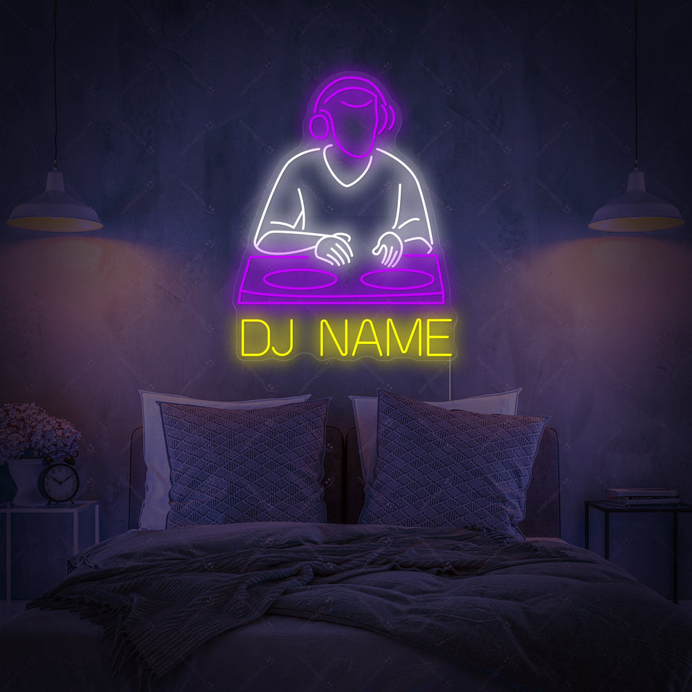 A custom neon sign displaying 'DJ NAME' in a blue, retro-futuristic font against a dark, brick bedroom wall, hanging above a desk with a gaming chair.