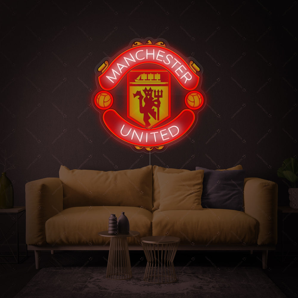A close-up view of the Manchester United logo rendered as a neon sign.