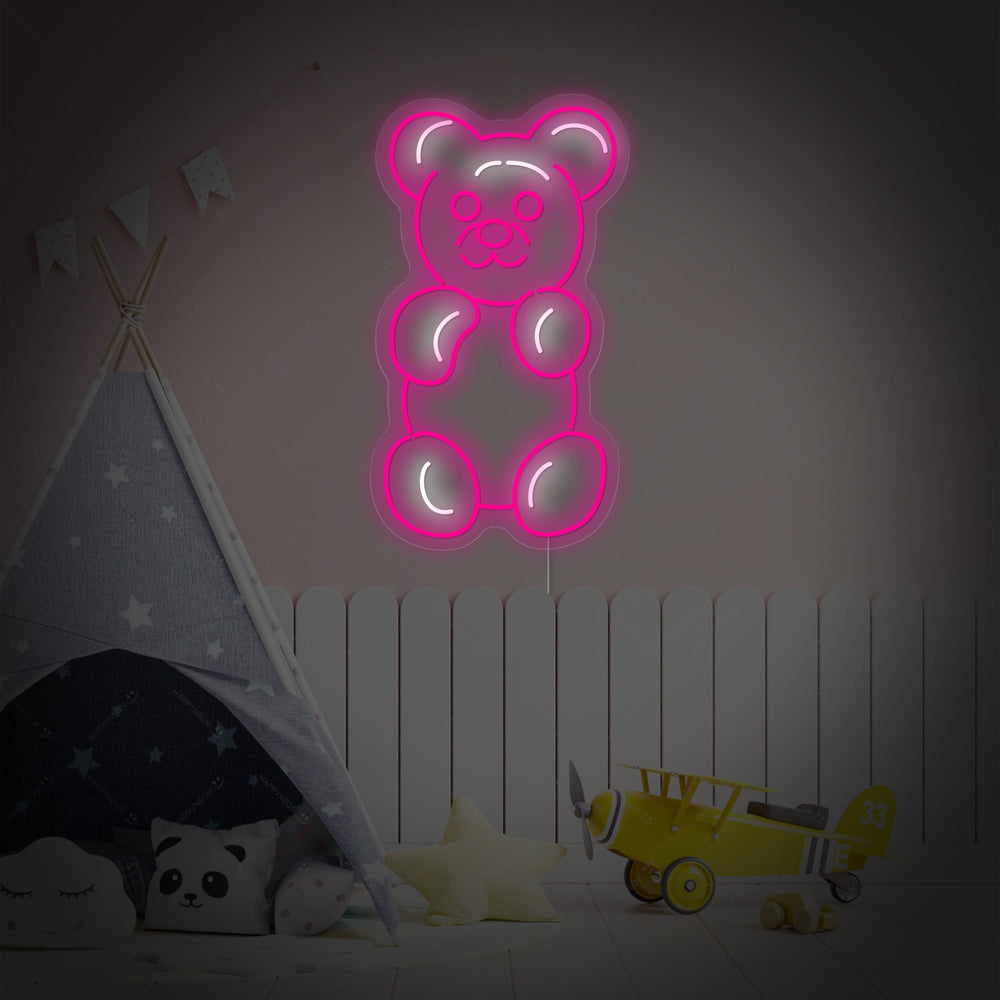 A charming, handcrafted neon sign in the shape of a gummy bear casting a cheerful orange light in a modern, staged children's bedroom setting.