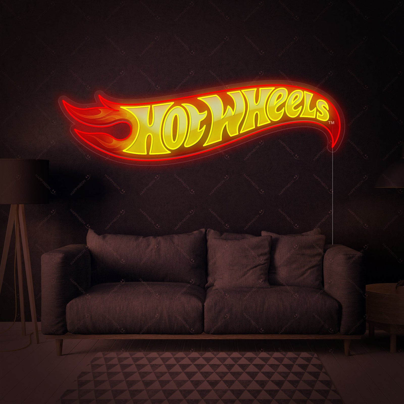 Digital mockup of a Hot Wheels logo neon sign graphic glowing above a sofa in a living room.